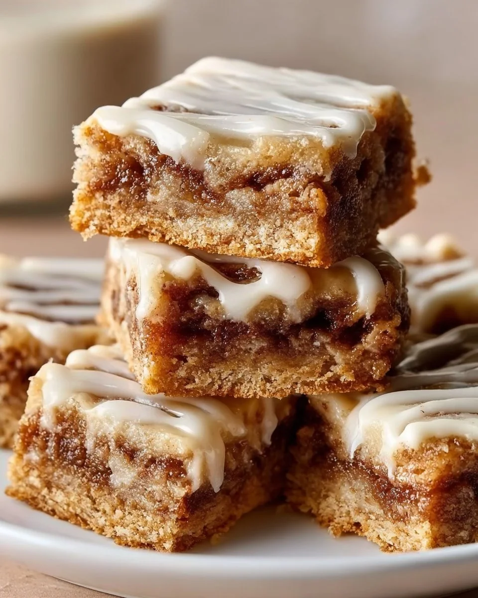 Delicious cinnamon roll bliss bars topped with icing on a clean white plate