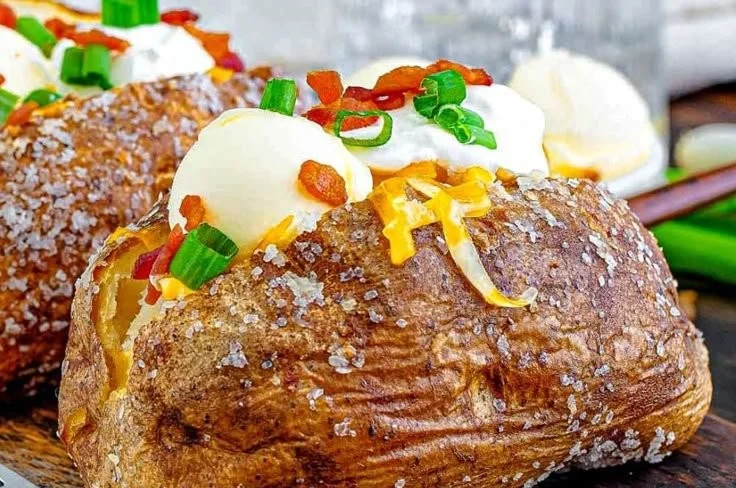 Delicious baked potato topped with butter and herbs