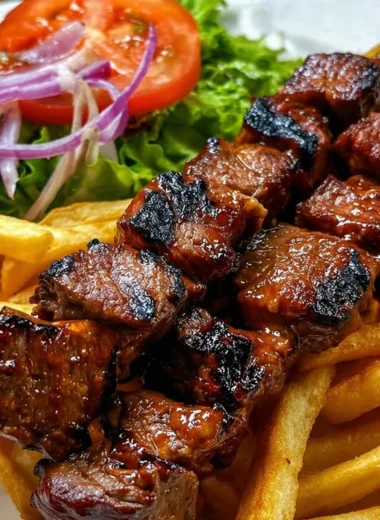 Delicious grilled steak skewers served with crispy fries on a plate