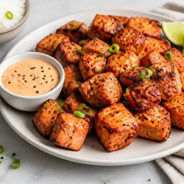 Creamy air fryer salmon bites with Bang Bang sauce on a plate