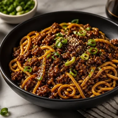 Mongolian Ground Beef Noodles garnished with vegetables in a bowl