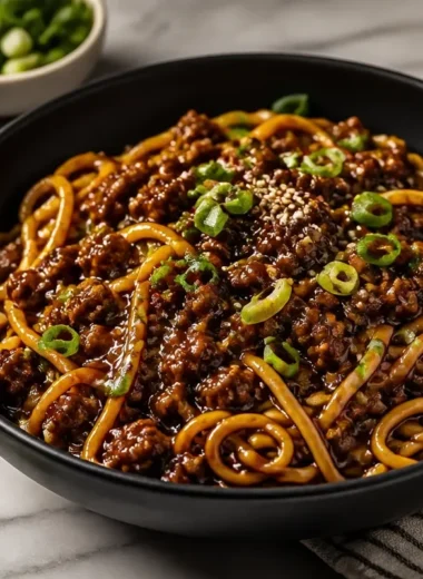 Mongolian Ground Beef Noodles garnished with vegetables in a bowl